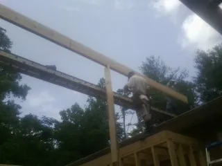 Carpenter setting a ridge beam over a new addition frame — Ice Dam Removal by Roofing Brothers in Honesdale