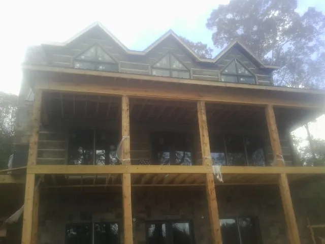 Dormers and porch framing on a large log home under construction — Roof Coating work by our crew in Honesdale