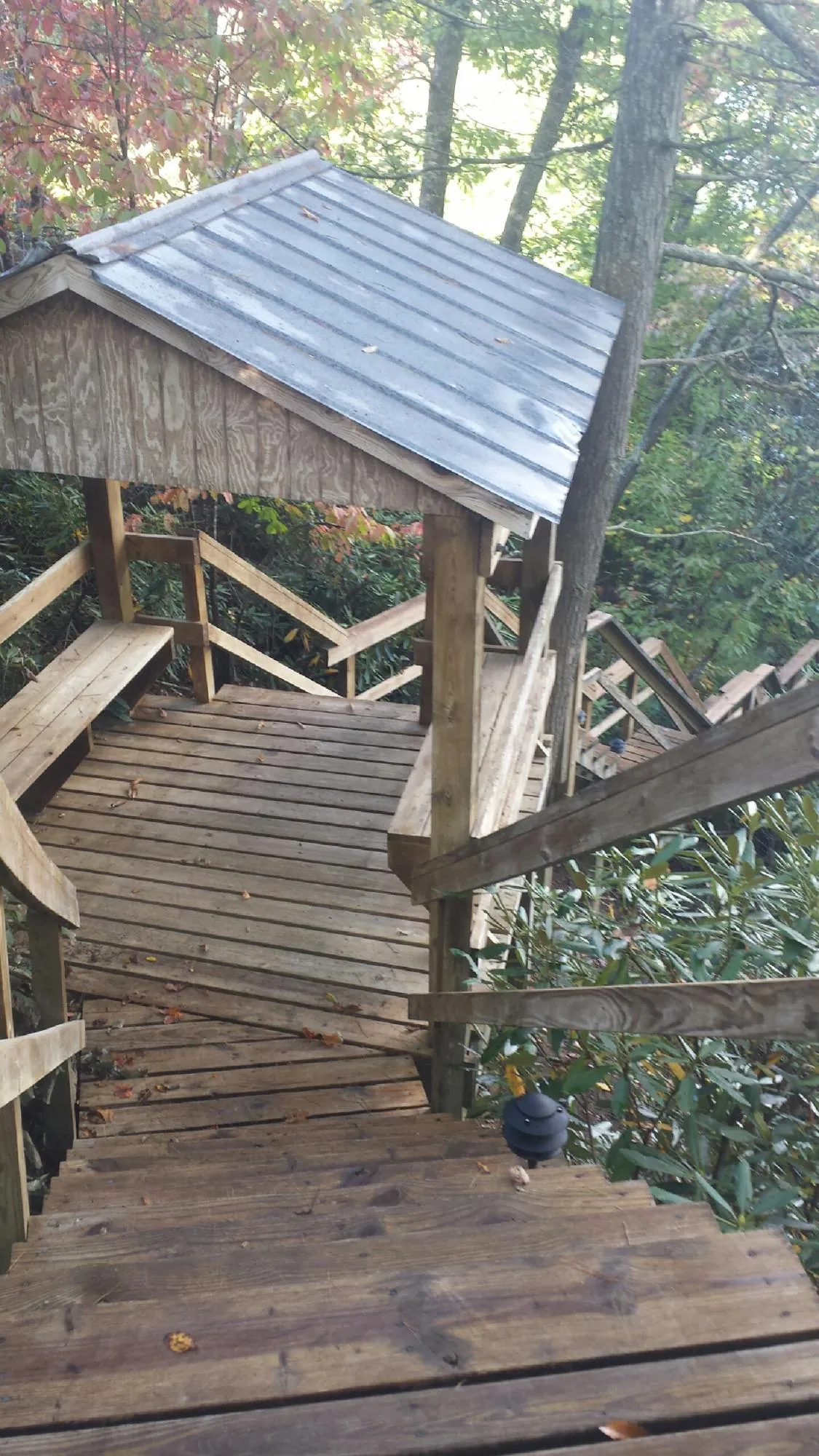 Metal roofed shelter over wooden steps on a wooded walkway — Skylight Repair & Installation work by our crew in Honesdale