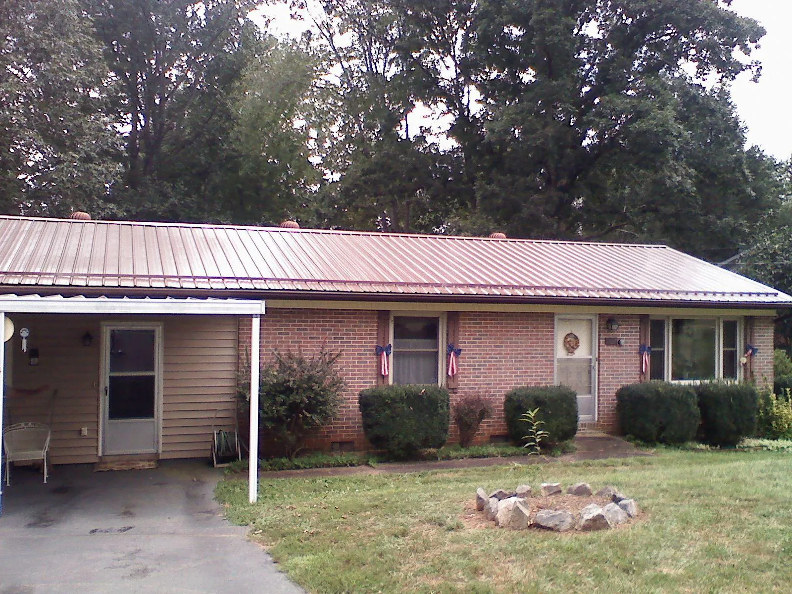 Bronze metal roof and carport on a brick ranch home — Roof Repair work by our crew in Honesdale