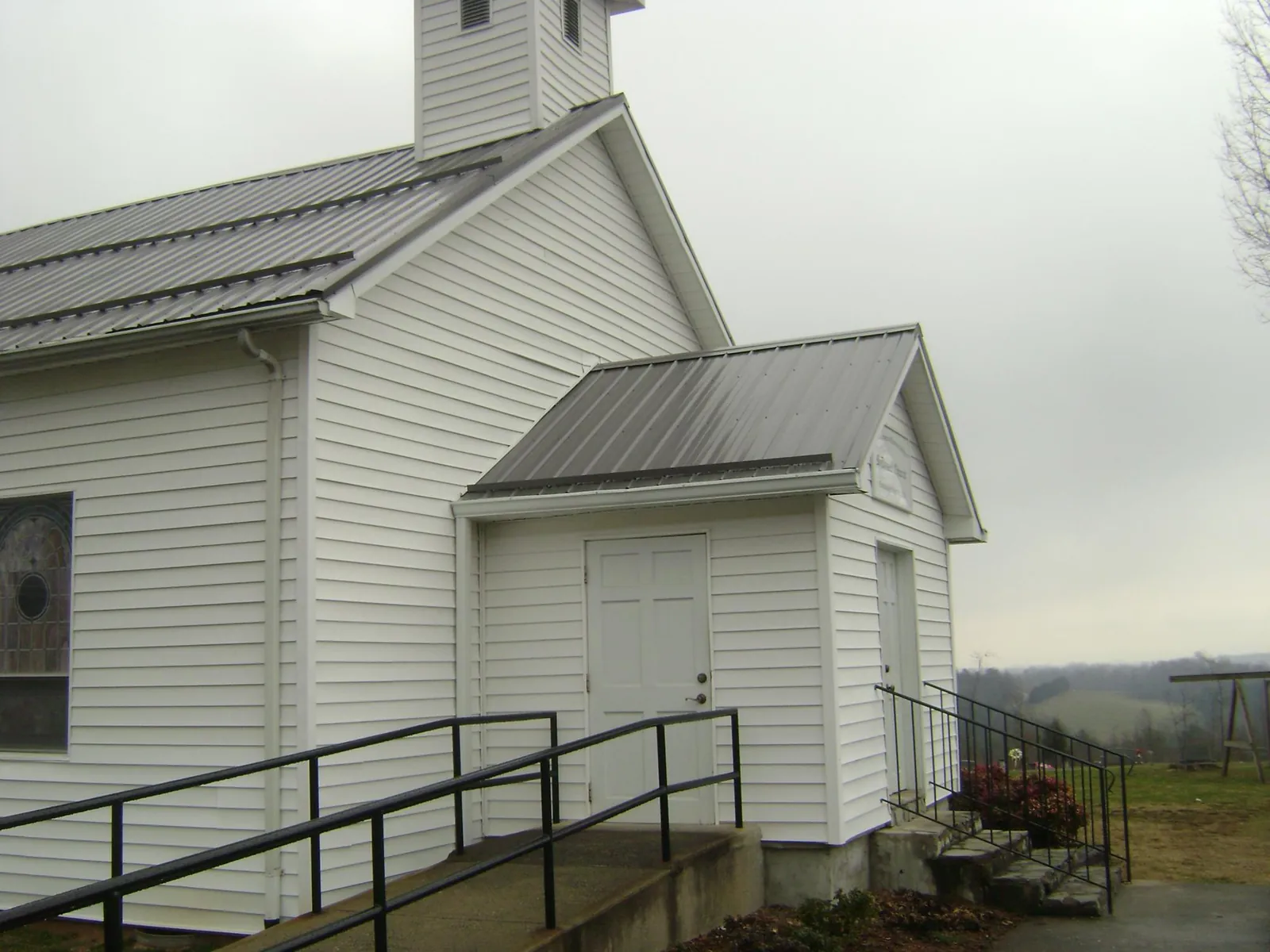 Gray metal roof on a white clapboard church with a steeple in Honesdale